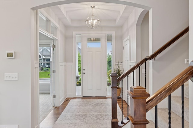 62 Rapp Farm Blvd, North Oaks, MN 55127 - foyer featuring arched walkways, healthy amount of natural light, a chandelier, stairs, and a decorative wall