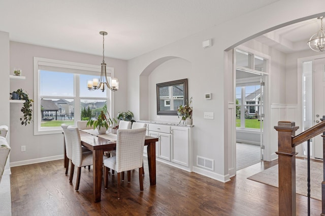 62 Rapp Farm Blvd, North Oaks, MN 55127 - dining space with a chandelier, dark wood-style floors, arched walkways, and baseboards