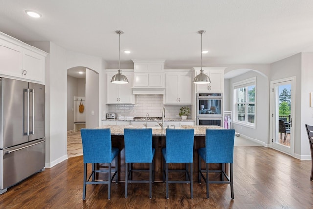 62 Rapp Farm Blvd, North Oaks, MN 55127 - kitchen with stainless steel appliances, arched walkways, baseboards, tasteful backsplash, and recessed lighting