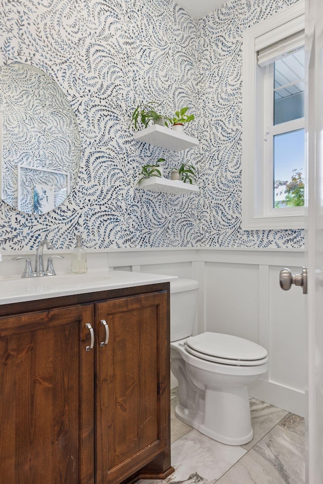 62 Rapp Farm Blvd, North Oaks, MN 55127 - half bathroom with wallpapered walls, toilet, wainscoting, vanity, and a decorative wall