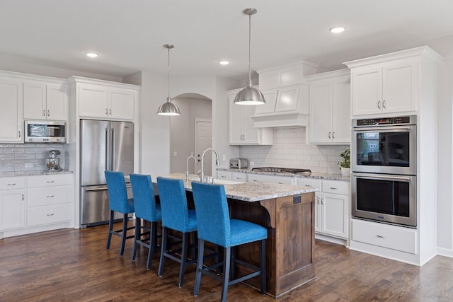 62 Rapp Farm Blvd, North Oaks, MN 55127 - kitchen with stainless steel appliances, tasteful backsplash, a kitchen bar, white cabinets, and recessed lighting