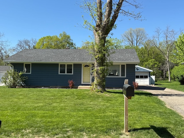 view of front of property with driveway, a garage, a front yard, and a shingled roof