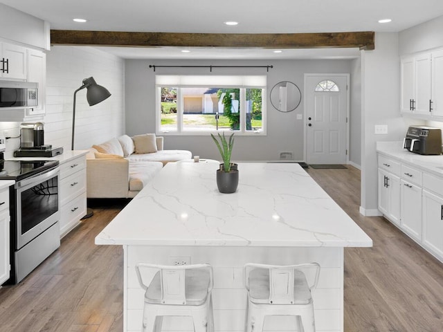 10308 Belmont Rd, Minnetonka, MN 55305 - kitchen with stainless steel appliances, beam ceiling, light wood-style floors, a center island, and recessed lighting