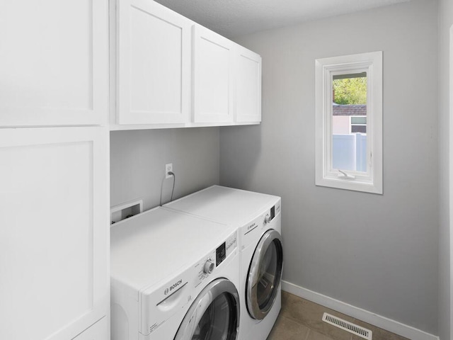 10308 Belmont Rd, Minnetonka, MN 55305 - laundry area with cabinet space, washer and dryer, baseboards, and dark tile patterned floors
