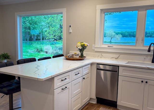 11445 State Highway 48, Trade Lake, WI 54853 - kitchen featuring stainless steel dishwasher, a kitchen breakfast bar, a peninsula, and light stone counters