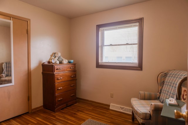 sitting room with dark wood finished floors and baseboards