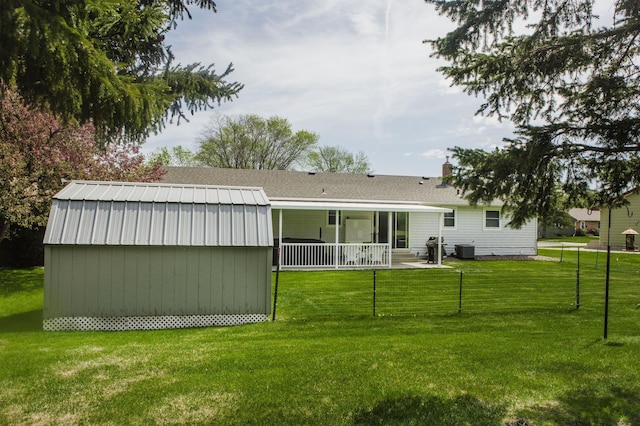 back of house featuring an outbuilding, central AC unit, and a storage unit