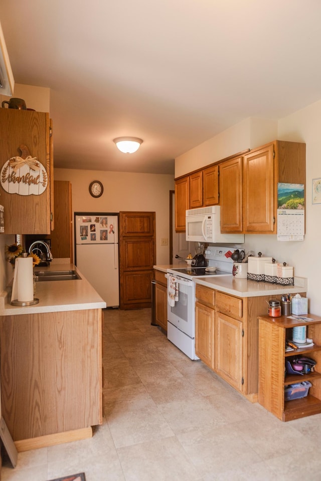 kitchen with white appliances, a sink, and light countertops