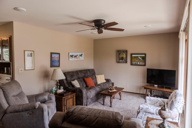 living area featuring carpet flooring, a ceiling fan, and baseboards
