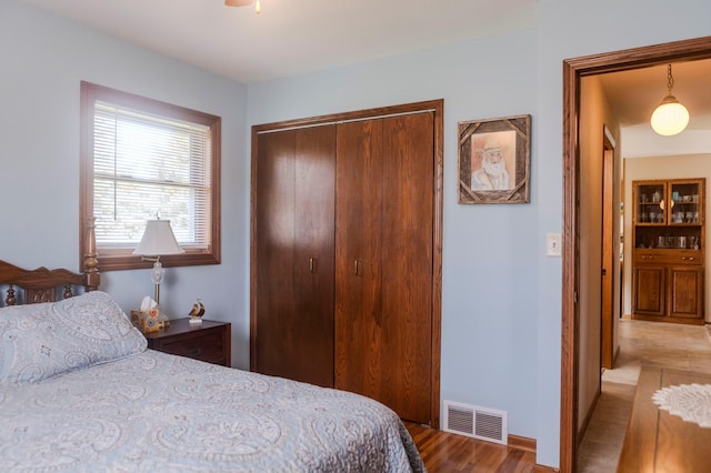 bedroom with a closet, wood finished floors, and baseboards