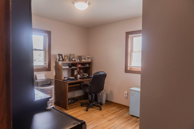 office area featuring light wood-type flooring, plenty of natural light, and baseboards