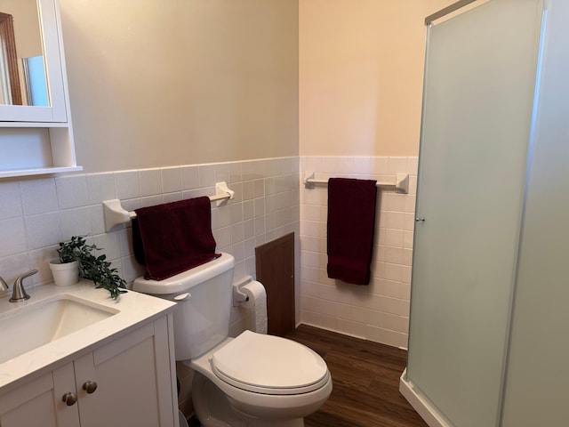 1601 8th Ave NE, Owatonna, MN 55060 - bathroom with tile walls, toilet, wood finished floors, wainscoting, and vanity