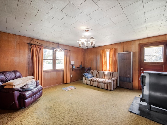 8418 State Highway 29 S, Alexandria, MN 56308 - carpeted living room with wooden walls, a chandelier, and a wood stove