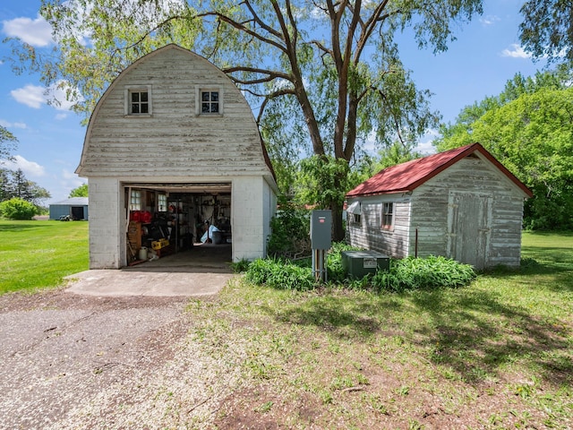 8418 State Highway 29 S, Alexandria, MN 56308 - view of home's exterior featuring a detached garage, central air condition unit, a lawn, and a gambrel roof