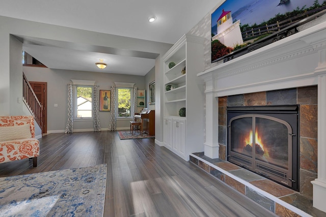 living room featuring wood finished floors, a fireplace, stairs, baseboards, and recessed lighting