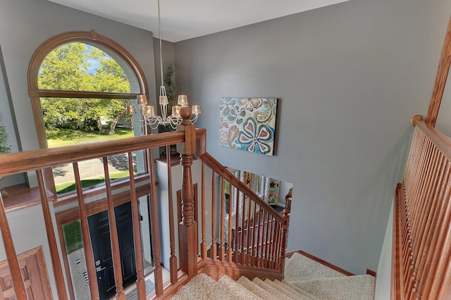 staircase featuring a chandelier
