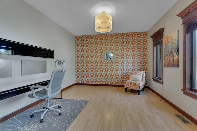 office featuring light wood-type flooring, wallpapered walls, baseboards, and healthy amount of natural light