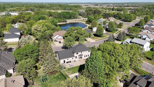 aerial view of property and surrounding area featuring nearby suburban area and a large body of water
