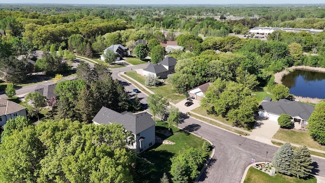 aerial perspective of suburban area featuring a heavily wooded area and a large body of water