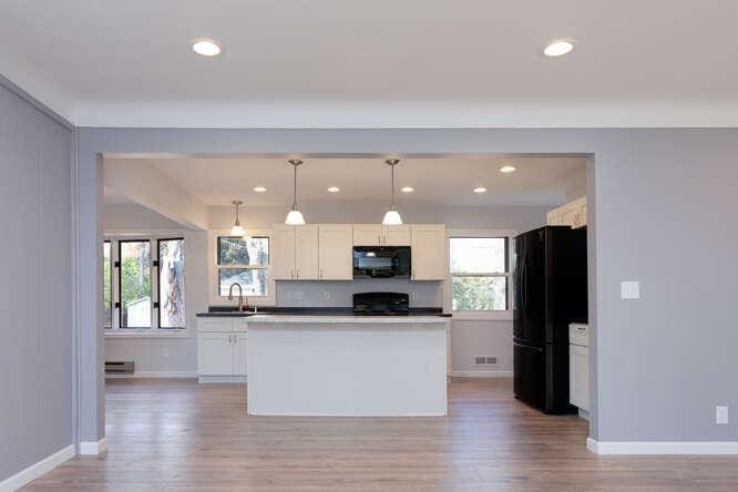 kitchen with black appliances, light wood-style flooring, baseboards, plenty of natural light, and recessed lighting