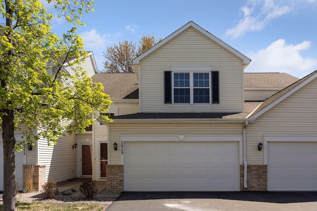 1515 Yorkshire Ln, Shakopee, MN 55379 - view of front facade with roof with shingles, asphalt driveway, brick siding, and a garage
