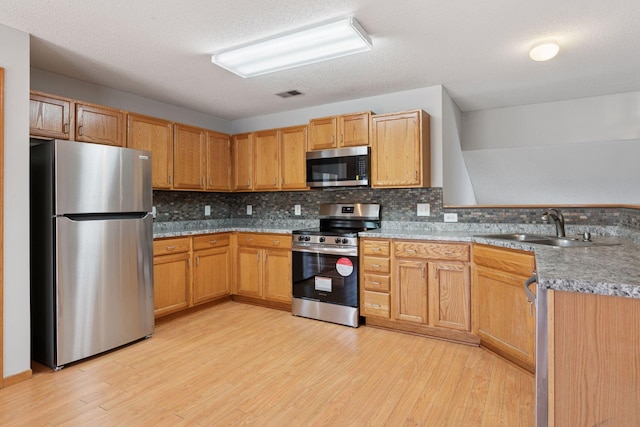 1515 Yorkshire Ln, Shakopee, MN 55379 - kitchen featuring stainless steel appliances, a sink, light wood-type flooring, a peninsula, and decorative backsplash
