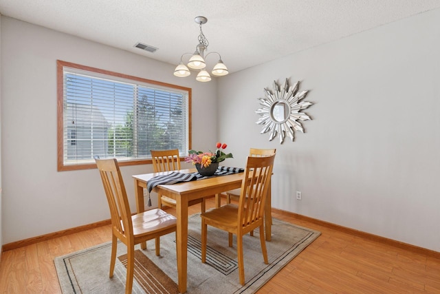 1515 Yorkshire Ln, Shakopee, MN 55379 - dining area with a chandelier, light wood finished floors, baseboards, and a textured ceiling