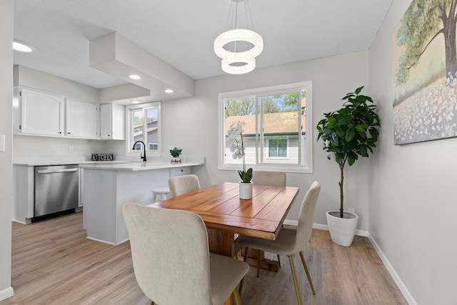dining room with light wood-type flooring, recessed lighting, a chandelier, and baseboards