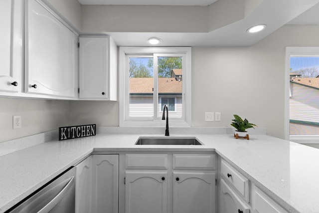 kitchen with a sink, stainless steel dishwasher, healthy amount of natural light, white cabinetry, and recessed lighting