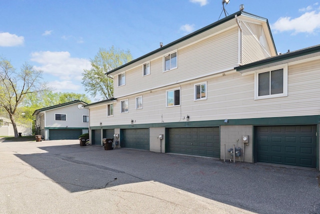 back of property featuring an attached garage and driveway