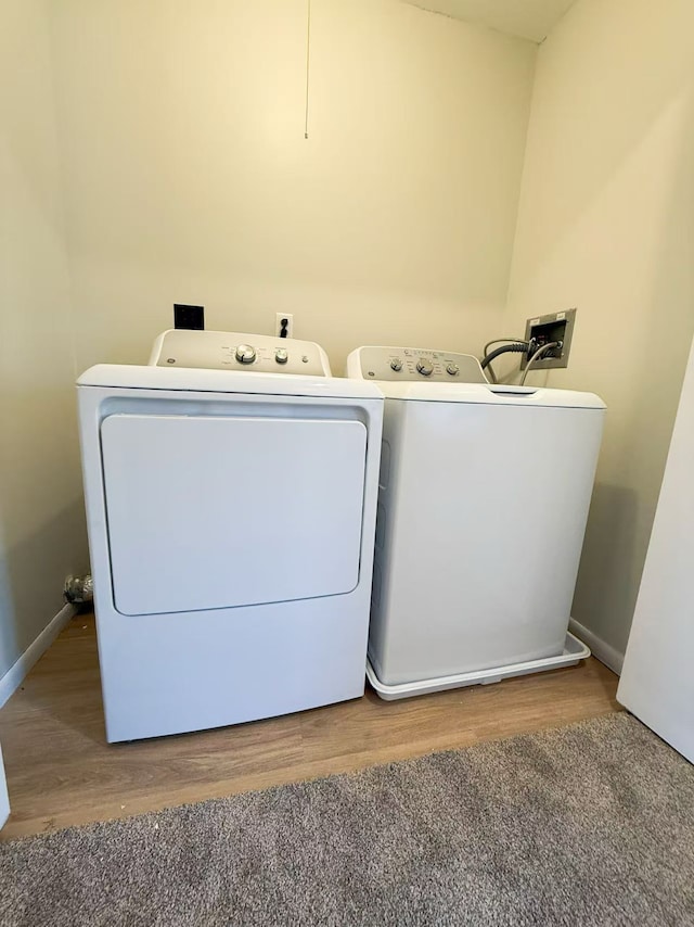 laundry room featuring washer and dryer, wood finished floors, and baseboards