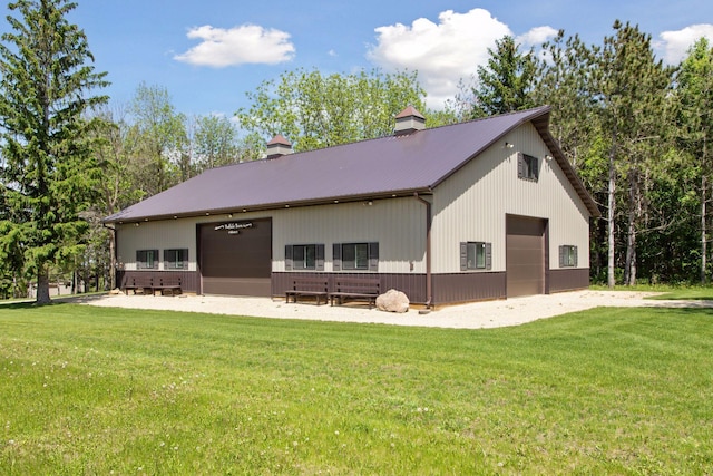 32875 Stanton Trl, Cannon Falls, MN 55009 - rear view of house featuring a chimney, a lawn, an outbuilding, and metal roof