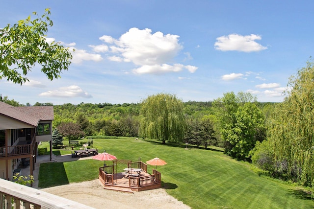 32875 Stanton Trl, Cannon Falls, MN 55009 - view of grassy yard featuring a wooden deck, a forest view, and a patio area