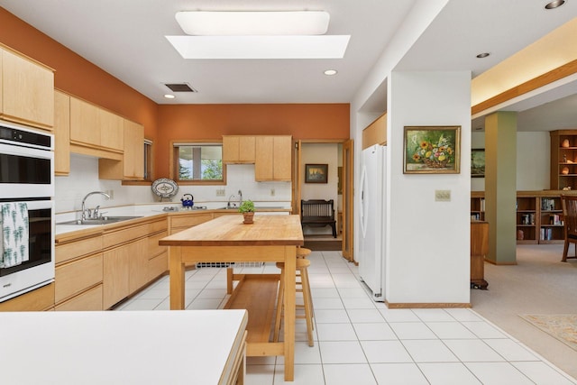 32875 Stanton Trl, Cannon Falls, MN 55009 - kitchen featuring white appliances, a sink, light brown cabinetry, a skylight, and recessed lighting