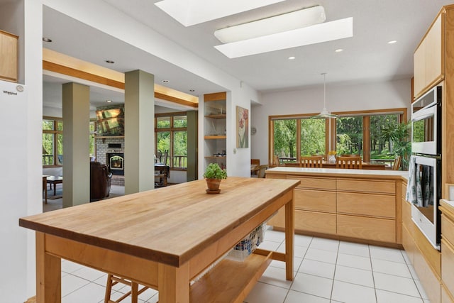 32875 Stanton Trl, Cannon Falls, MN 55009 - kitchen featuring a skylight, double oven, a brick fireplace, recessed lighting, and light tile patterned floors
