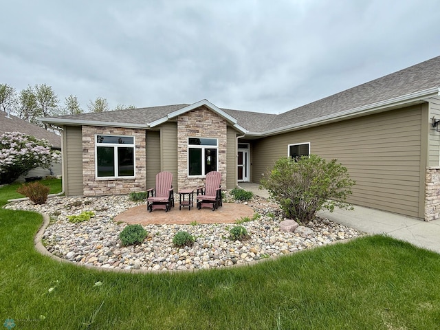 3823 43rd Ave S, Moorhead, MN 56560 - rear view of property with stone siding, a shingled roof, a patio, and a lawn