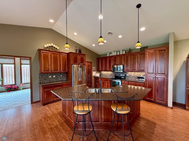 3823 43rd Ave S, Moorhead, MN 56560 - kitchen with appliances with stainless steel finishes, a sink, light wood-type flooring, decorative backsplash, and a kitchen island with sink