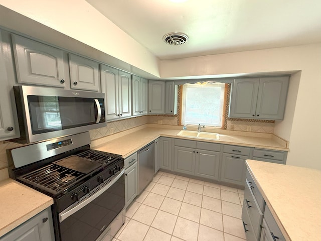 1611 Graydon Ave, Brainerd, MN 56401 - kitchen with appliances with stainless steel finishes, tasteful backsplash, light countertops, gray cabinets, and light tile patterned flooring