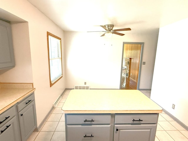 1611 Graydon Ave, Brainerd, MN 56401 - kitchen with ceiling fan, gray cabinetry, a center island, and light tile patterned floors