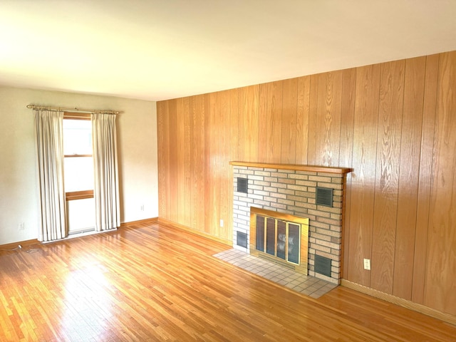 1611 Graydon Ave, Brainerd, MN 56401 - unfurnished living room featuring wood finished floors, a brick fireplace, and wood walls
