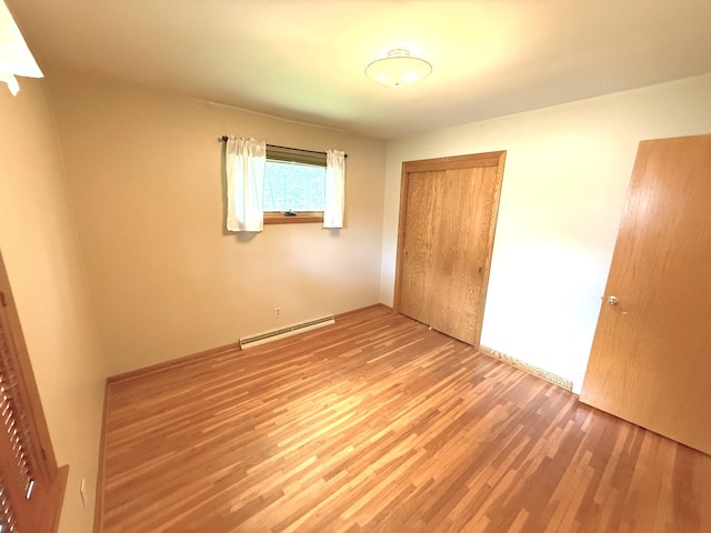 1611 Graydon Ave, Brainerd, MN 56401 - unfurnished bedroom with a baseboard radiator, wood finished floors, and a closet