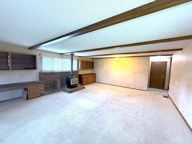 1611 Graydon Ave, Brainerd, MN 56401 - unfurnished living room with beam ceiling, a wood stove, carpet, and a textured ceiling