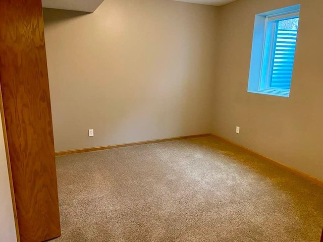 carpeted spare room with baseboards