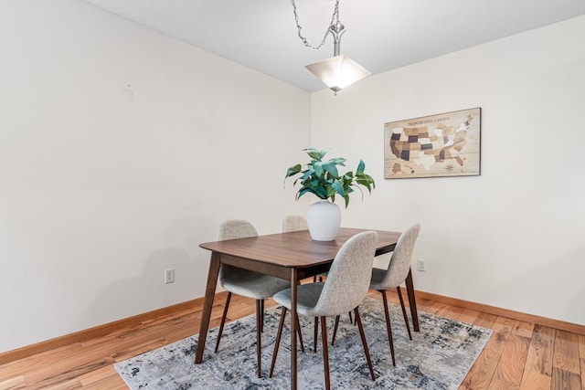 dining space featuring baseboards and wood finished floors