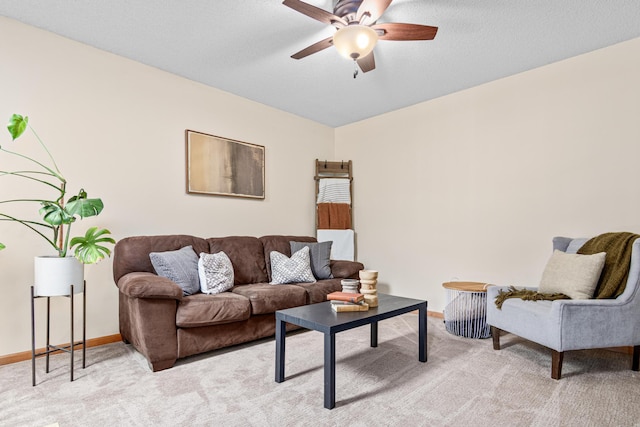 living area featuring light colored carpet, a ceiling fan, and baseboards