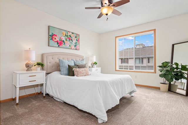 carpeted bedroom featuring baseboards, a ceiling fan, and a textured ceiling