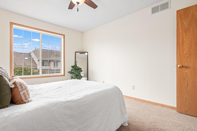 carpeted bedroom with baseboards, a ceiling fan, and a textured ceiling