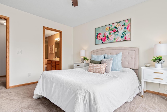 carpeted bedroom featuring baseboards, ensuite bath, and ceiling fan