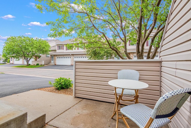 view of patio / terrace with asphalt driveway and a residential view