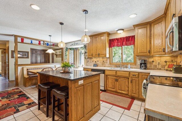 5651 164th Ln NW, Ramsey, MN 55303 - kitchen featuring appliances with stainless steel finishes, a sink, tasteful backsplash, a kitchen bar, and a textured ceiling